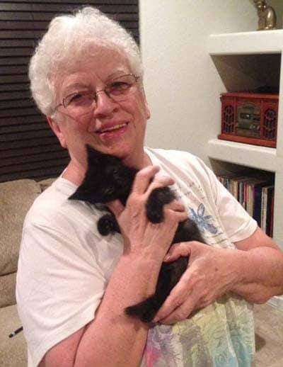 Kathy holding her black kitten Ollie.